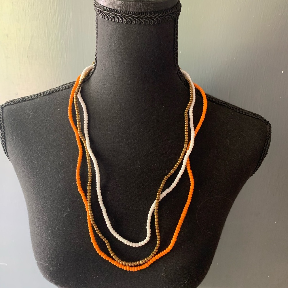 Three bead necklaces. Orange white copper. Beads strung on raffia type material